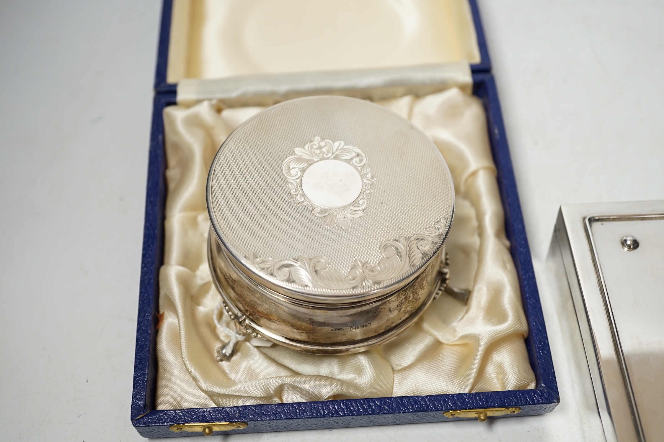 A modern engine turned silver trinket box, Birmingham, 1984, diameter, 82mm, together with a Greek 925 mounted cigarette box by Zolotas, 15cm.